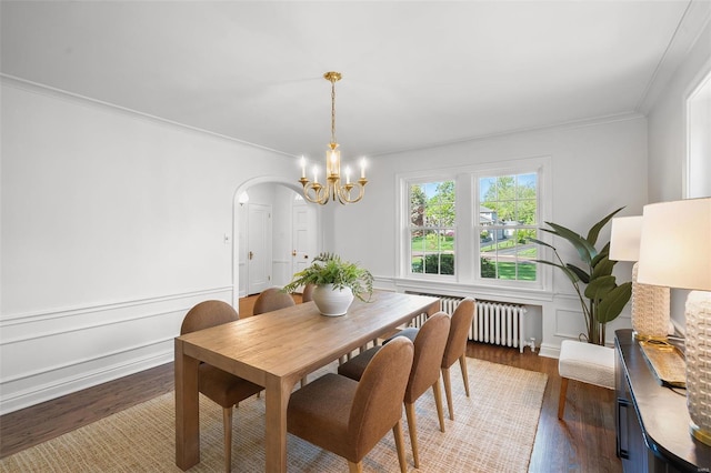 dining room with crown molding, dark wood-type flooring, radiator heating unit, and a chandelier
