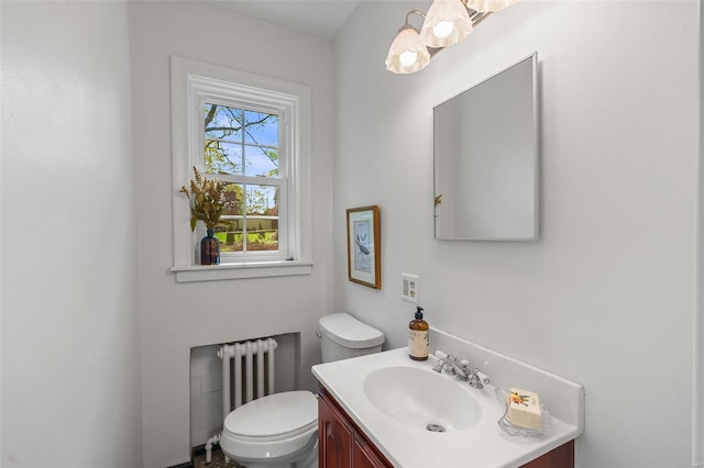bathroom with vanity, radiator heating unit, and toilet