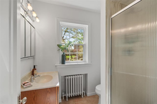 full bath featuring tile patterned flooring, a shower with shower door, vanity, toilet, and radiator heating unit