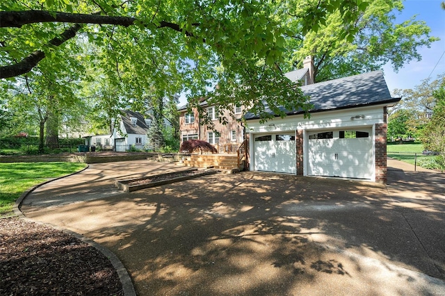 view of front of home featuring fence, a shingled roof, brick siding, aphalt driveway, and a chimney