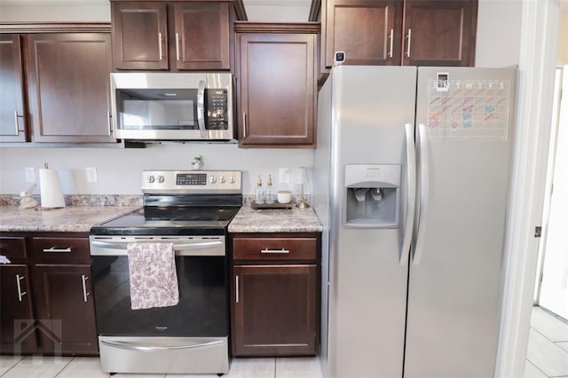 kitchen featuring light tile patterned flooring, dark brown cabinets, and appliances with stainless steel finishes