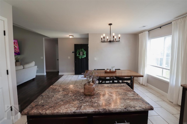 dining room with baseboards and a notable chandelier