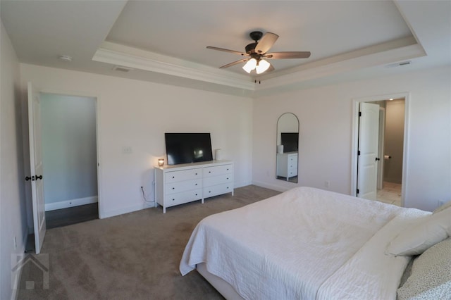 carpeted bedroom with visible vents, baseboards, a ceiling fan, and a tray ceiling