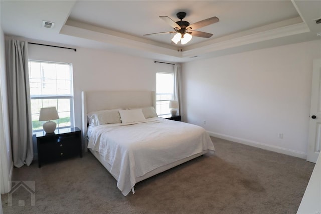 carpeted bedroom with visible vents and a raised ceiling