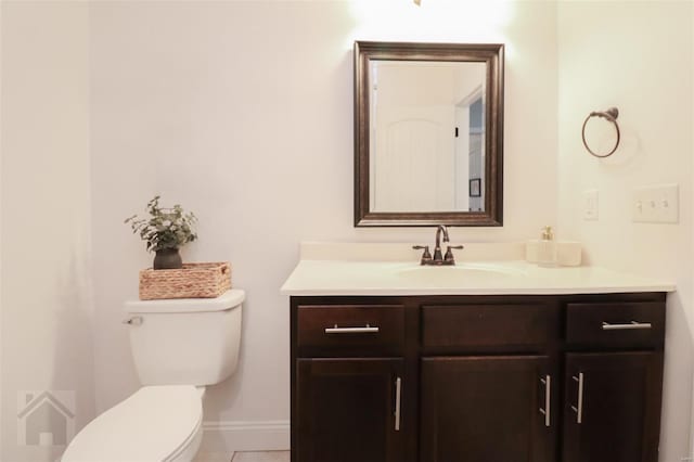 bathroom featuring toilet, vanity, tile patterned floors, and baseboards