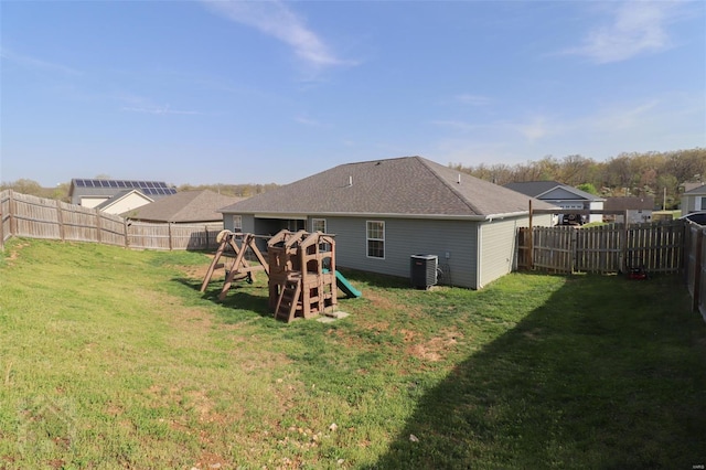 back of house featuring a fenced backyard, central air condition unit, and a lawn