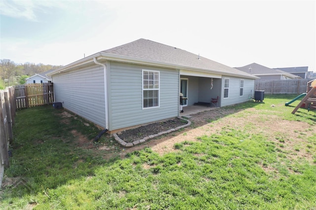 back of house with a fenced backyard, cooling unit, a playground, a yard, and a patio