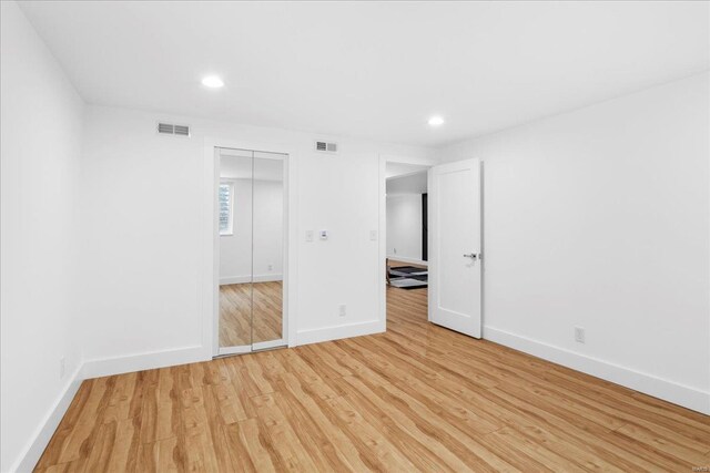 unfurnished bedroom with baseboards, visible vents, and light wood-style floors