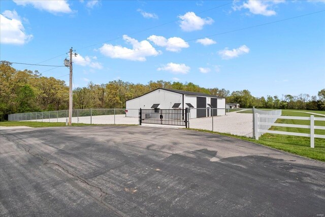 exterior space with an outdoor structure, fence, a gate, and a garage