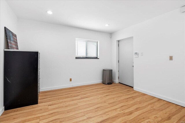 empty room featuring baseboards, recessed lighting, and light wood-style flooring