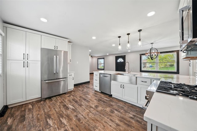 kitchen with a sink, appliances with stainless steel finishes, recessed lighting, and dark wood finished floors
