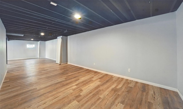 below grade area with baseboards and wood finished floors