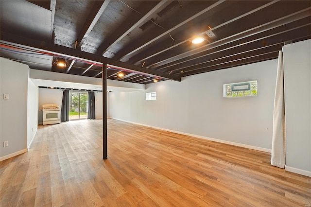 basement with baseboards and wood finished floors