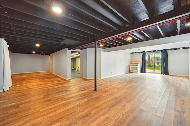 below grade area with baseboards and wood finished floors