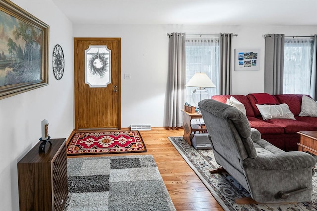living room with visible vents, a healthy amount of sunlight, and wood finished floors