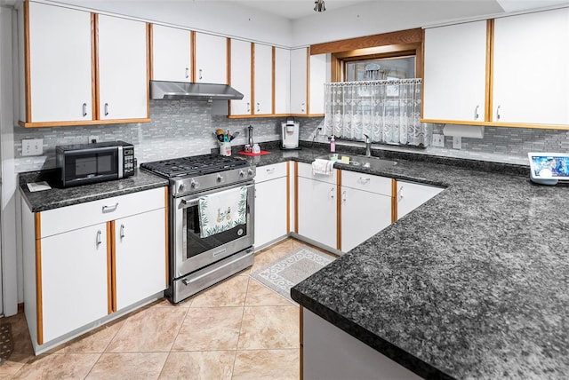 kitchen with decorative backsplash, gas stove, a sink, under cabinet range hood, and white cabinetry