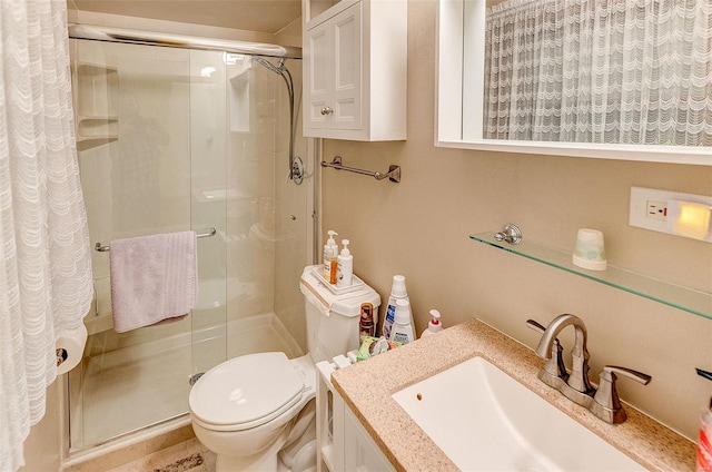 bathroom featuring vanity, toilet, and a shower stall