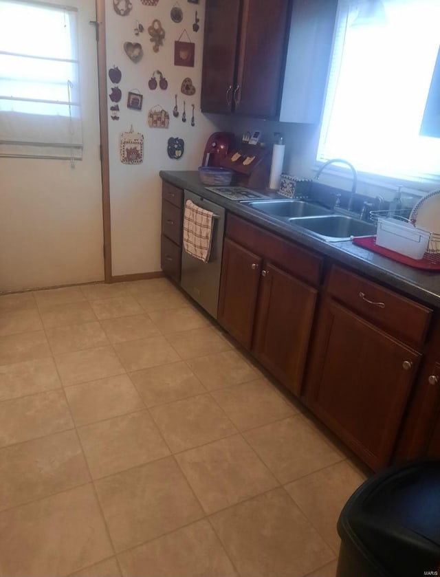 kitchen with a sink, dark countertops, and dishwasher