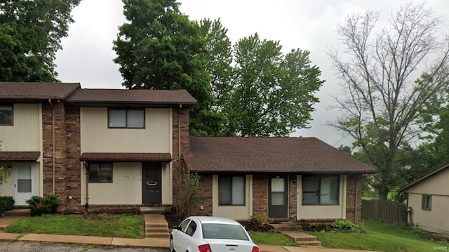 view of front of home with brick siding and fence