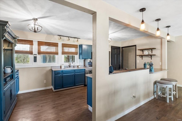 kitchen with baseboards, dark wood-style floors, blue cabinets, and a sink