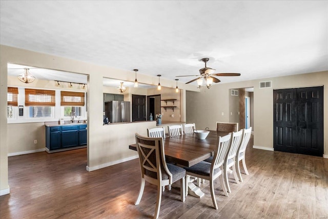 dining room featuring wood finished floors, visible vents, baseboards, and ceiling fan