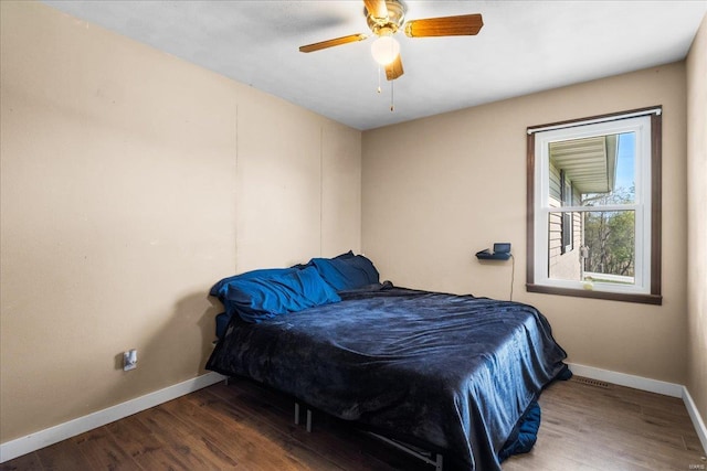 bedroom featuring visible vents, wood finished floors, baseboards, and ceiling fan
