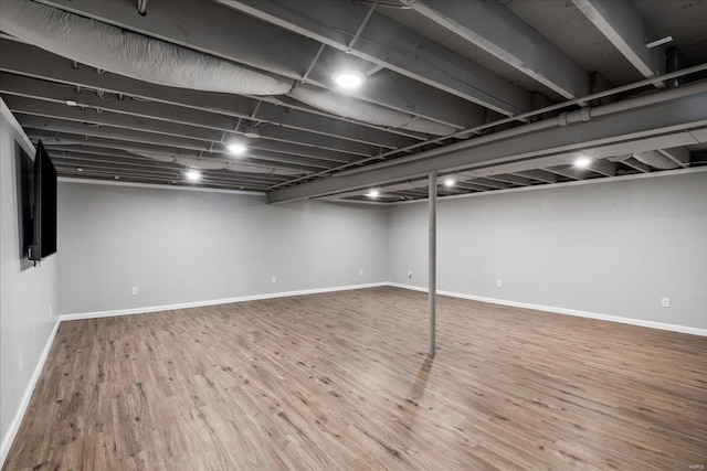 finished below grade area with wood finished floors and baseboards