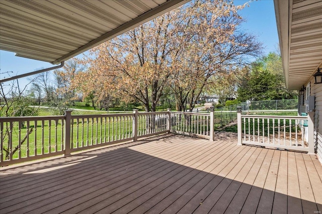 wooden terrace with a yard and fence