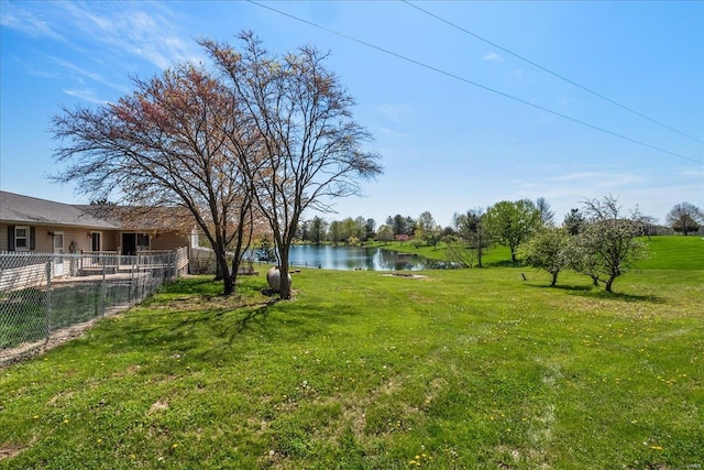 view of yard featuring a water view and fence