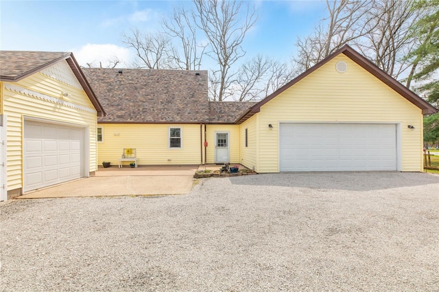 view of front of property with a garage, roof with shingles, and driveway