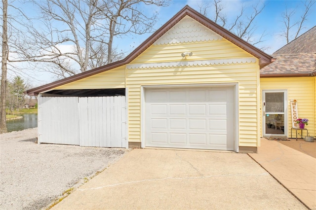 garage with driveway and a water view