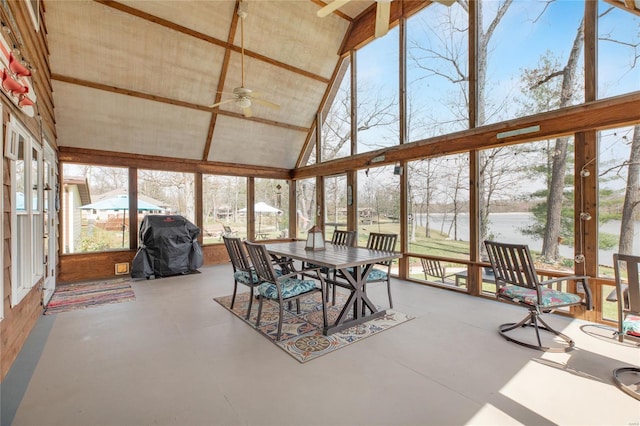sunroom with a water view, outdoor dining space, ceiling fan, and a wealth of natural light