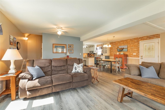 living room with light wood-style floors and ceiling fan with notable chandelier