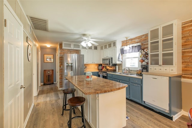 kitchen featuring a ceiling fan, visible vents, blue cabinets, a sink, and stainless steel appliances