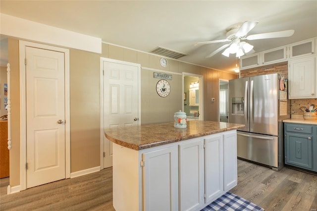 kitchen with light wood-style flooring, ceiling fan, visible vents, and stainless steel refrigerator with ice dispenser