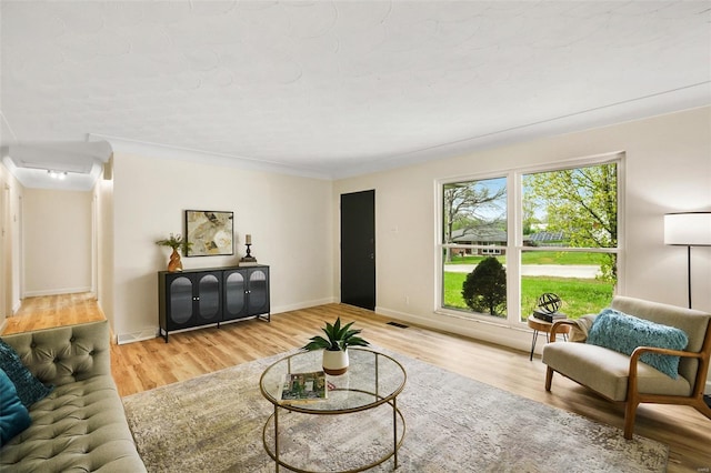 living area with baseboards and wood finished floors