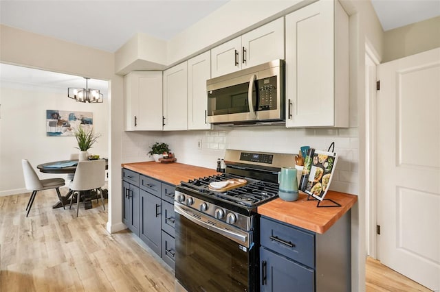kitchen with butcher block countertops, white cabinets, light wood finished floors, and stainless steel appliances