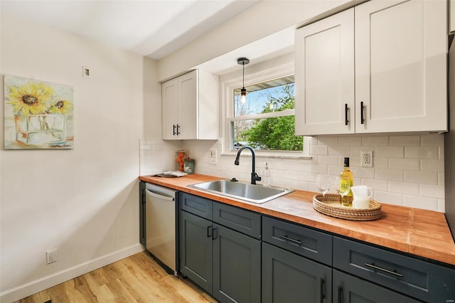 kitchen featuring a sink, white cabinetry, dishwasher, and butcher block counters