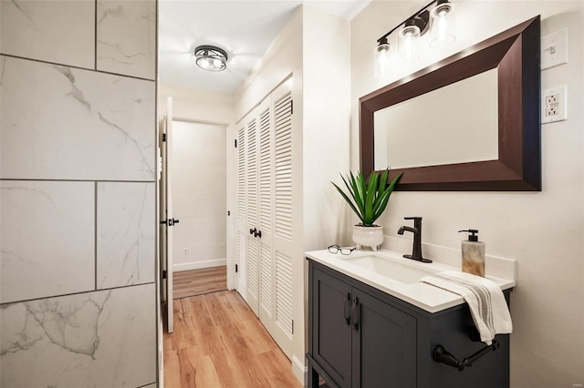 bathroom featuring vanity, baseboards, and wood finished floors