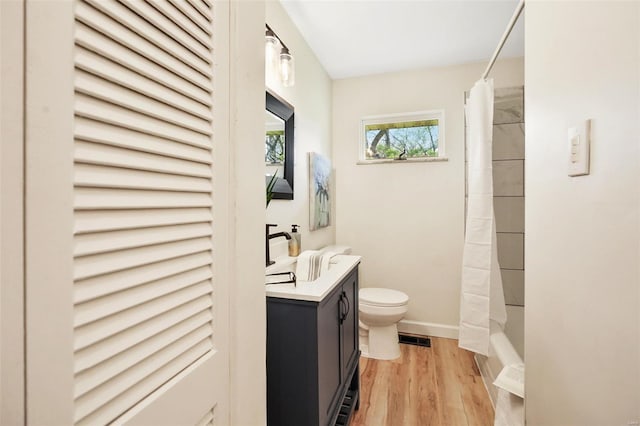 full bath featuring vanity, visible vents, toilet, wood finished floors, and baseboards