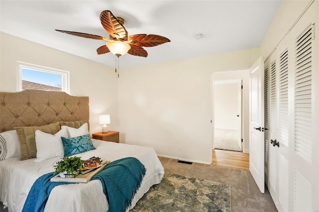 carpeted bedroom featuring a closet, baseboards, and ceiling fan