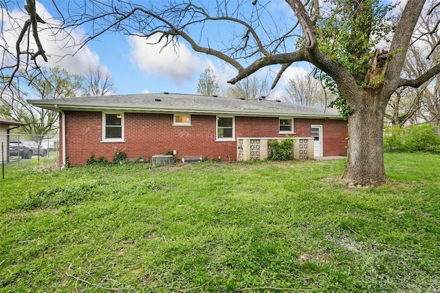 rear view of house with a yard, brick siding, fence, and central AC unit