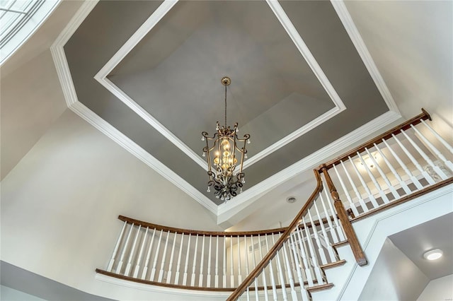 details featuring crown molding, a notable chandelier, and a raised ceiling