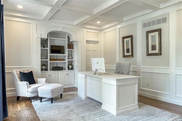 office with beamed ceiling, a decorative wall, and light wood-style flooring