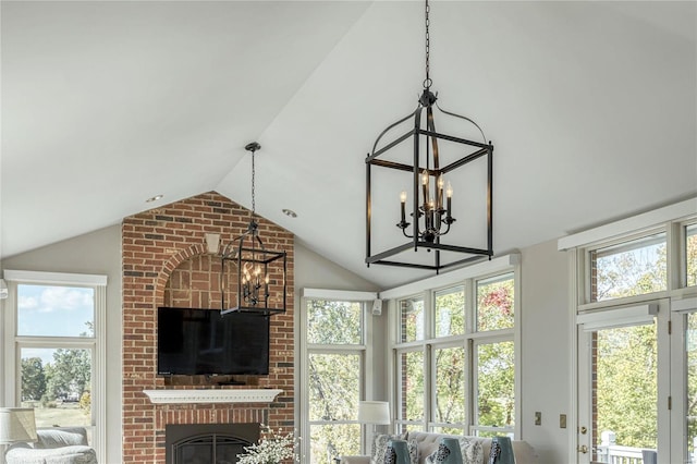 living room with a healthy amount of sunlight, a fireplace, lofted ceiling, and a chandelier
