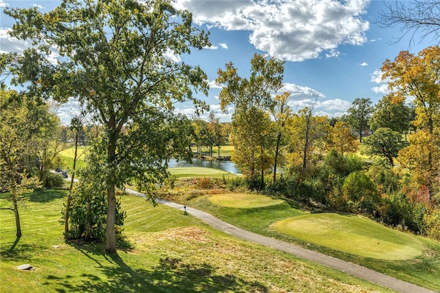 surrounding community with a water view, view of golf course, and a yard