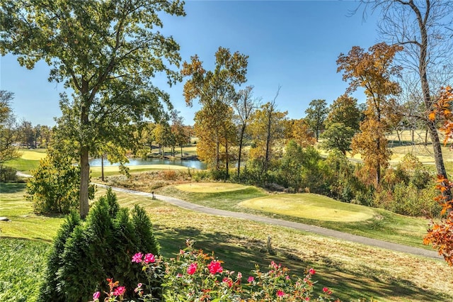 view of home's community featuring a water view, golf course view, and a yard