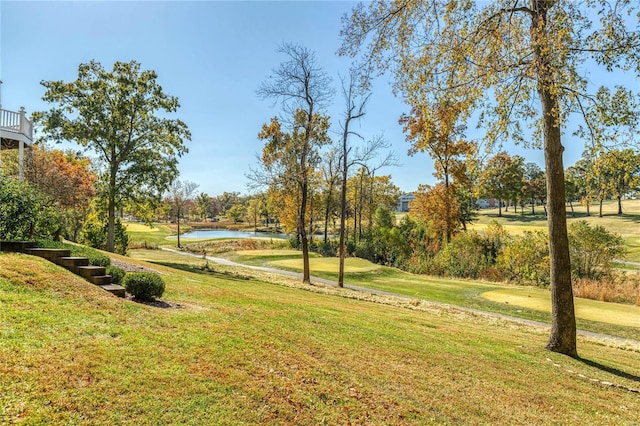 view of home's community with a yard, a water view, and golf course view