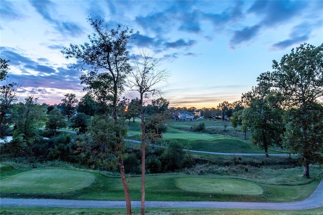 view of home's community with view of golf course and a yard