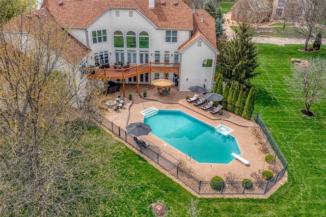 back of house featuring a deck, a patio, a fenced backyard, outdoor dining area, and a yard